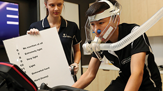 Exercise sports science student Lucy Cleggett with jockey Gary Lo, who is having his respiratory physiology analysed as part of a unique UniSA study. Photo by Sarah Reed, The Advertiser.
